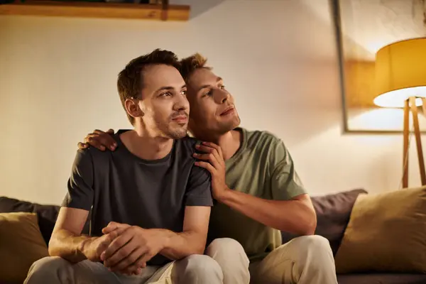 Two men share a tender moment while relaxing in their cozy living space. — Stock Photo