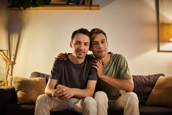 Dois homens compartilham um momento terno juntos em seu sofá aconchegante. — Fotografia de Stock