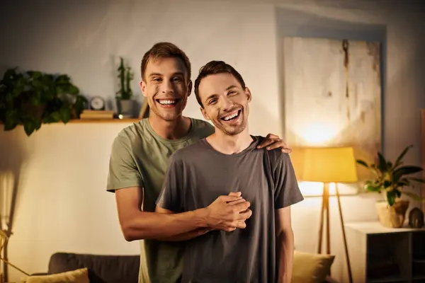 Two men share laughter and warmth in their cozy living room. — Stock Photo