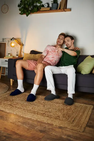Two men share a tender moment on their cozy sofa, basking in each other. — Stock Photo