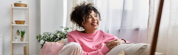 A joyful young woman relaxes in her cozy living room. — Stock Photo