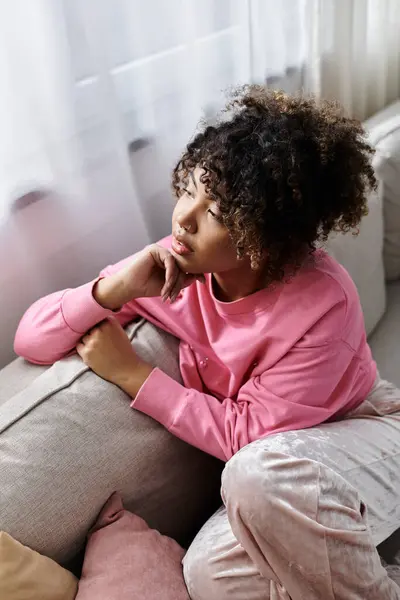 A young woman enjoys a quiet moment of reflection while lounging indoors. — Stock Photo