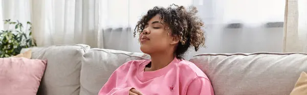 Une jeune femme profite d'un moment paisible à la maison, perdu dans la pensée et la tranquillité. — Photo de stock