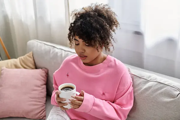 Relaxing at home, a woman savors her coffee in a comfortable setting. — Stock Photo
