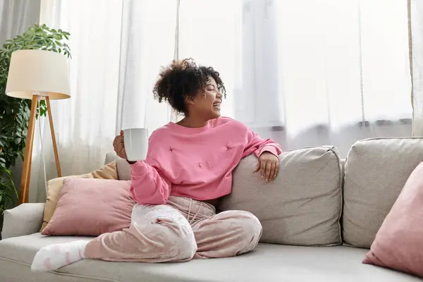 A woman enjoys her time at home with a warm cup in hand, embracing comfort and tranquility. — Stock Photo