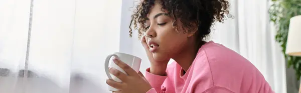 Uma jovem mulher desfrutando de um momento de paz com sua bebida. — Fotografia de Stock