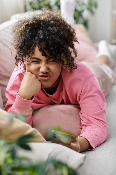 A beautiful woman lounges comfortably, lost in thought at home. — Stock Photo