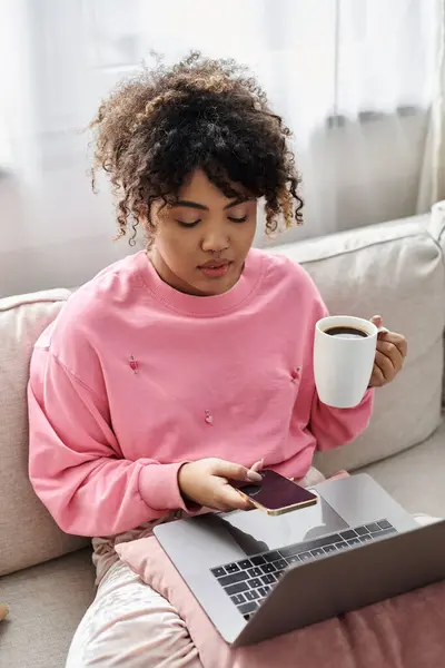 Relaxing at home, she checks her phone with a warm cup of coffee. — Stock Photo