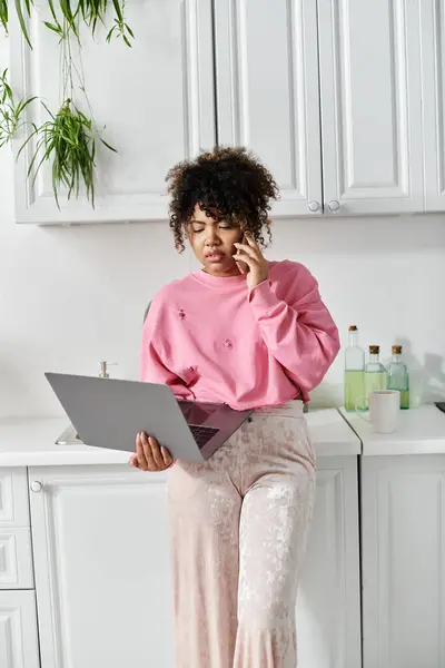 Una giovane donna si connette con qualcuno mentre multitasking a casa. — Foto stock