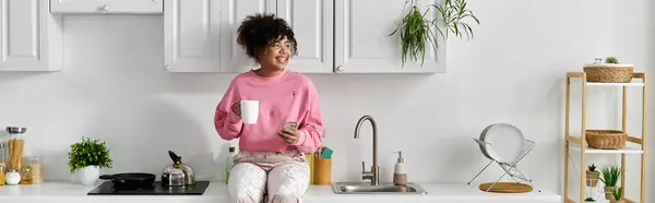 A cheerful woman enjoys a cozy moment with her drink at home. — Stock Photo