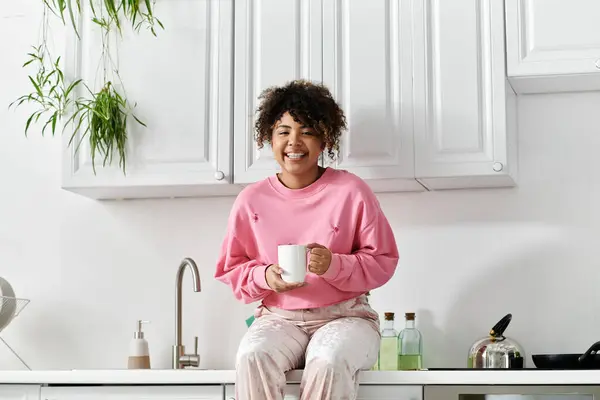 A young woman savors her warm beverage while relaxing at home. — Stock Photo