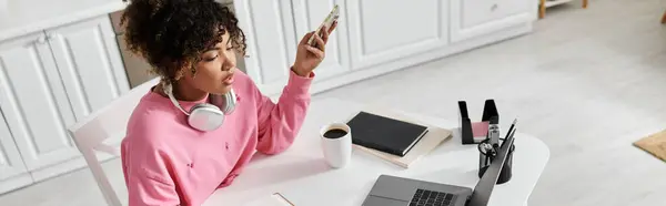 Relaxed woman smiles while working at her desk with coffee and headphones. — Stock Photo