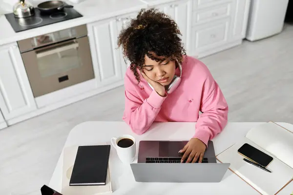 A woman relaxes at home, focused on her laptop with a cup of coffee beside her. — Stock Photo