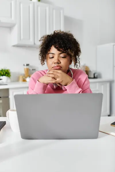 Contempler des idées tout en travaillant sur un ordinateur portable dans un cadre de cuisine sereine. — Stock Photo