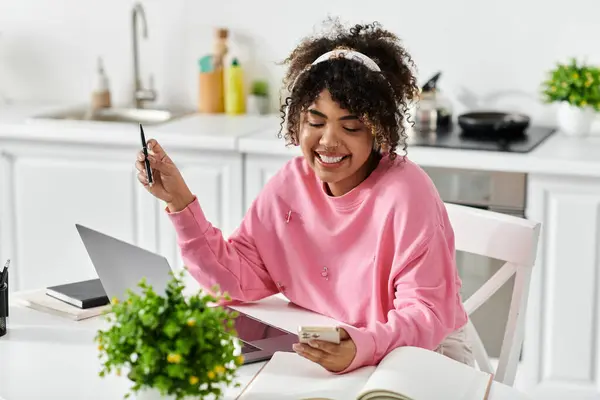 Una mujer alegre se involucra en la creatividad y la productividad en su acogedor espacio en casa. - foto de stock