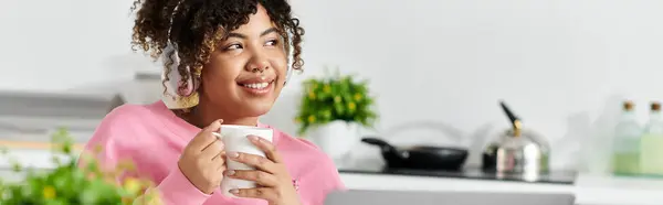 Smiling woman relaxes with a cup in her bright, inviting kitchen. — Stock Photo