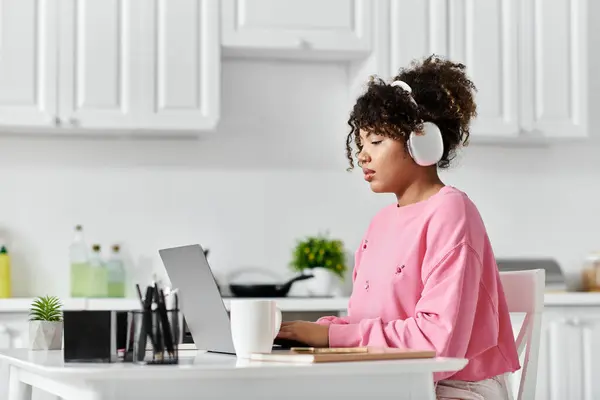 A young woman immersed in her work, wearing headphones and relaxed at home. — Stock Photo