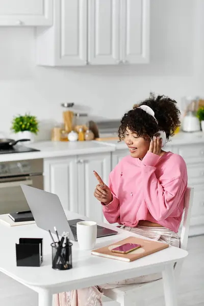 Una giovane donna gioiosa si impegna in una videochiamata dalla sua luminosa cucina. — Foto stock