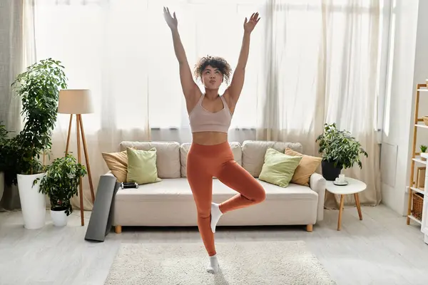 Eine junge Frau genießt einen Moment Yoga und Selbstpflege in ihrem gemütlichen Zuhause. — Stockfoto