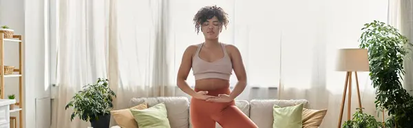 A young woman enjoys yoga, creating a peaceful atmosphere at home. — Stock Photo