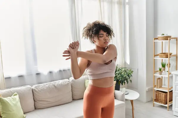 A young woman enjoys a peaceful moment stretching at home. — Stock Photo