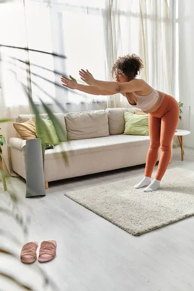 A young woman stretches while enjoying a peaceful moment at home. — Stock Photo