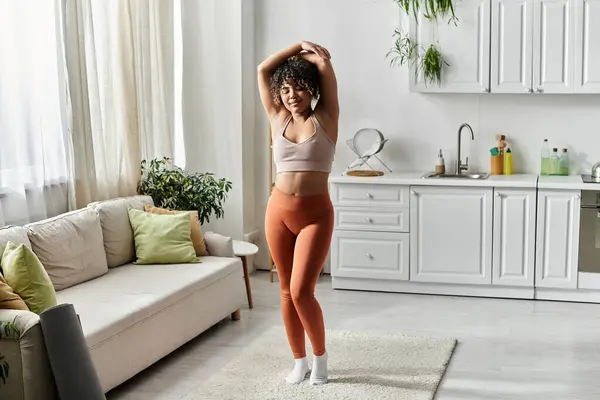 Une femme joyeuse se déplace gracieusement dans son environnement de maison élégant. — Photo de stock