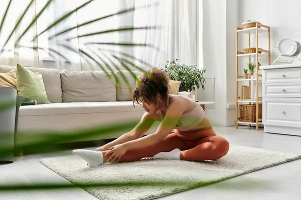 A young woman stretches peacefully at home, enjoying a relaxing moment. — Stock Photo
