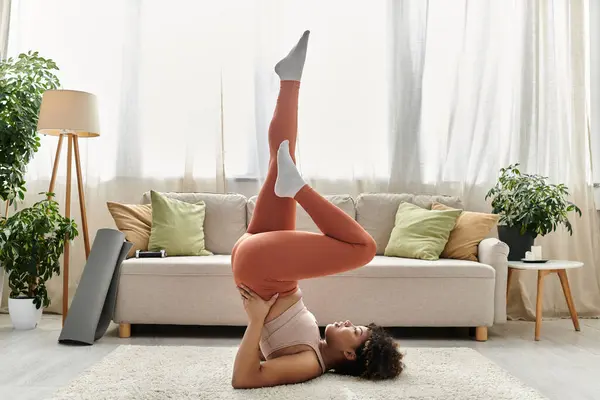 A young woman performs yoga while relaxing in her home. — Stock Photo