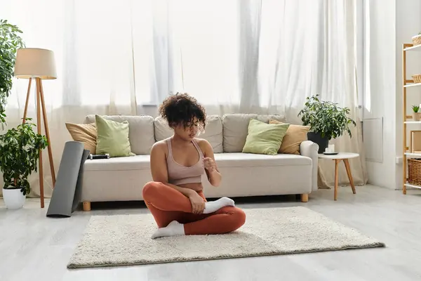A young woman engages in mindfulness practice in her inviting home space. — Stock Photo