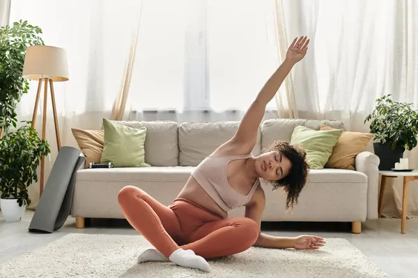 Eine junge Frau streckt sich anmutig in ihrem gemütlichen Wohnzimmer voller Pflanzen. — Stockfoto