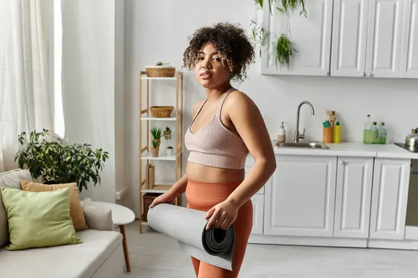 Una mujer se prepara para el yoga en su acogedora y elegante sala de estar. — Stock Photo