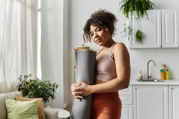Eine junge Frau bereitet sich in ihrem stilvollen Wohnumfeld auf Yoga vor. — Stockfoto