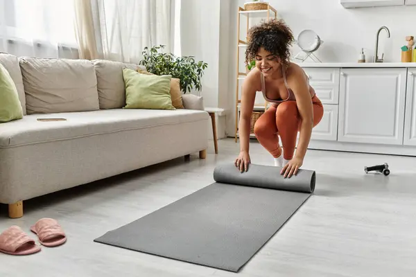 She prepares to practice yoga in her cozy living room filled with natural light. — Stock Photo