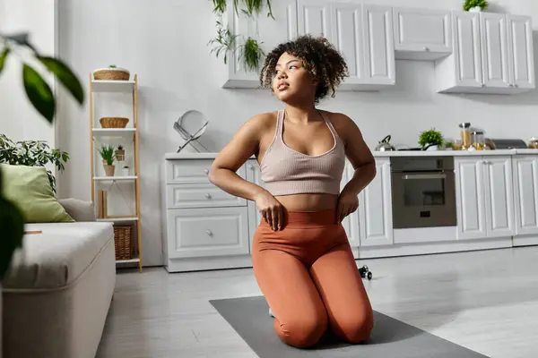 A young woman practices yoga, embracing tranquility in her stylish living space. — Stock Photo