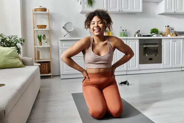 Una donna gioiosa gode di un momento di yoga nel suo elegante spazio cucina. — Foto stock