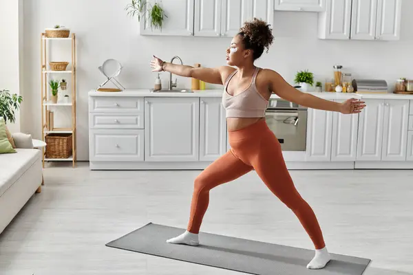 A beautiful woman engages in yoga practice surrounded by a bright interior. — Stock Photo