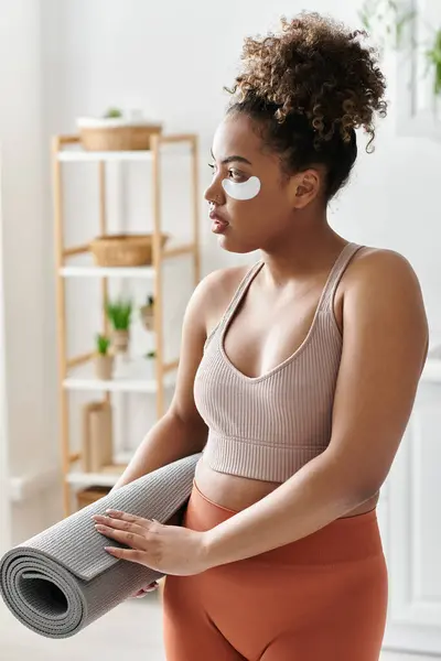 Woman prepares for a calming yoga session in a cozy living space. — Stock Photo