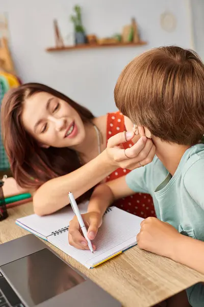 Eine Mutter kümmert sich liebevoll um ihren schwerhörigen Sohn, während sie gemeinsam lernen. — Stockfoto