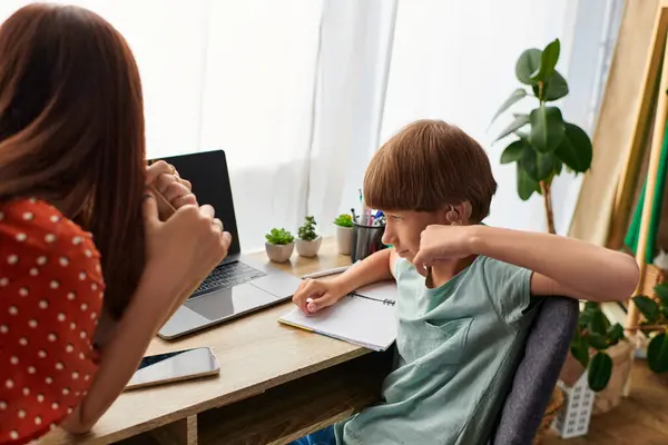 Uma mãe amorosa se envolve com seu filho deficiente auditivo durante o tempo de estudo. — Fotografia de Stock
