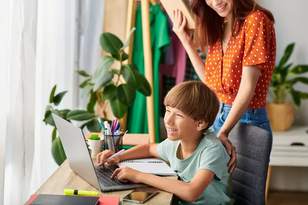 A mother shares laughter with her son as they engage in learning together. — Stock Photo