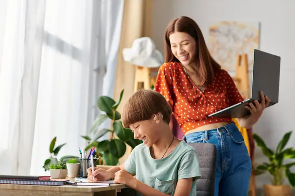 A mother supports her son as he enjoys drawing and learning at a cozy desk. — Stock Photo