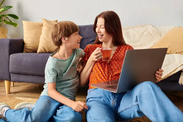 A loving mother shares laughter with her hearing impaired son over a laptop. — Stock Photo