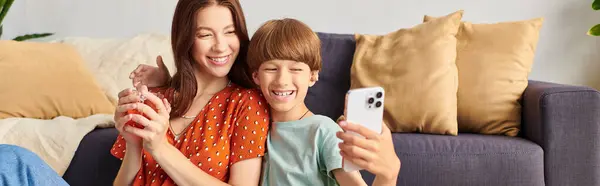 A joyful mother shares a delightful moment with her son, capturing their laughter. — Stock Photo