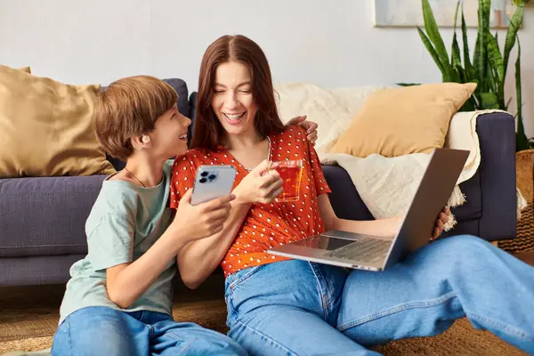 A mother and her son share laughter while exploring a smartphone together. — Stock Photo