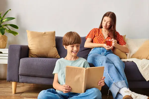 Une mère joyeuse profite d'un moment tranquille avec son fils malentendant pendant qu'il lit. — Stock Photo