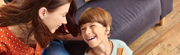 A mother shares laughter and love with her hearing impaired son at home. — Stock Photo