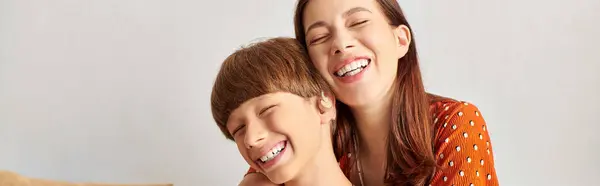 Mother and her hearing impaired son share laughter and hugs in a cozy setting. — Stock Photo