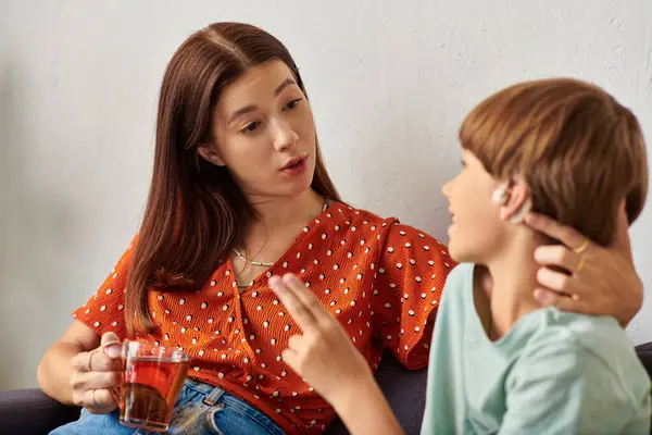 Une mère engage une conversation avec son fils malentendant tout en dégustant du thé. — Photo de stock