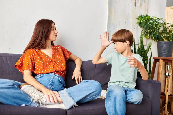 A mother engages with her son, using sign language and playful expressions. — Stock Photo